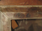 caption: Lettering on the reverse of stretcher, showing through wax lining.